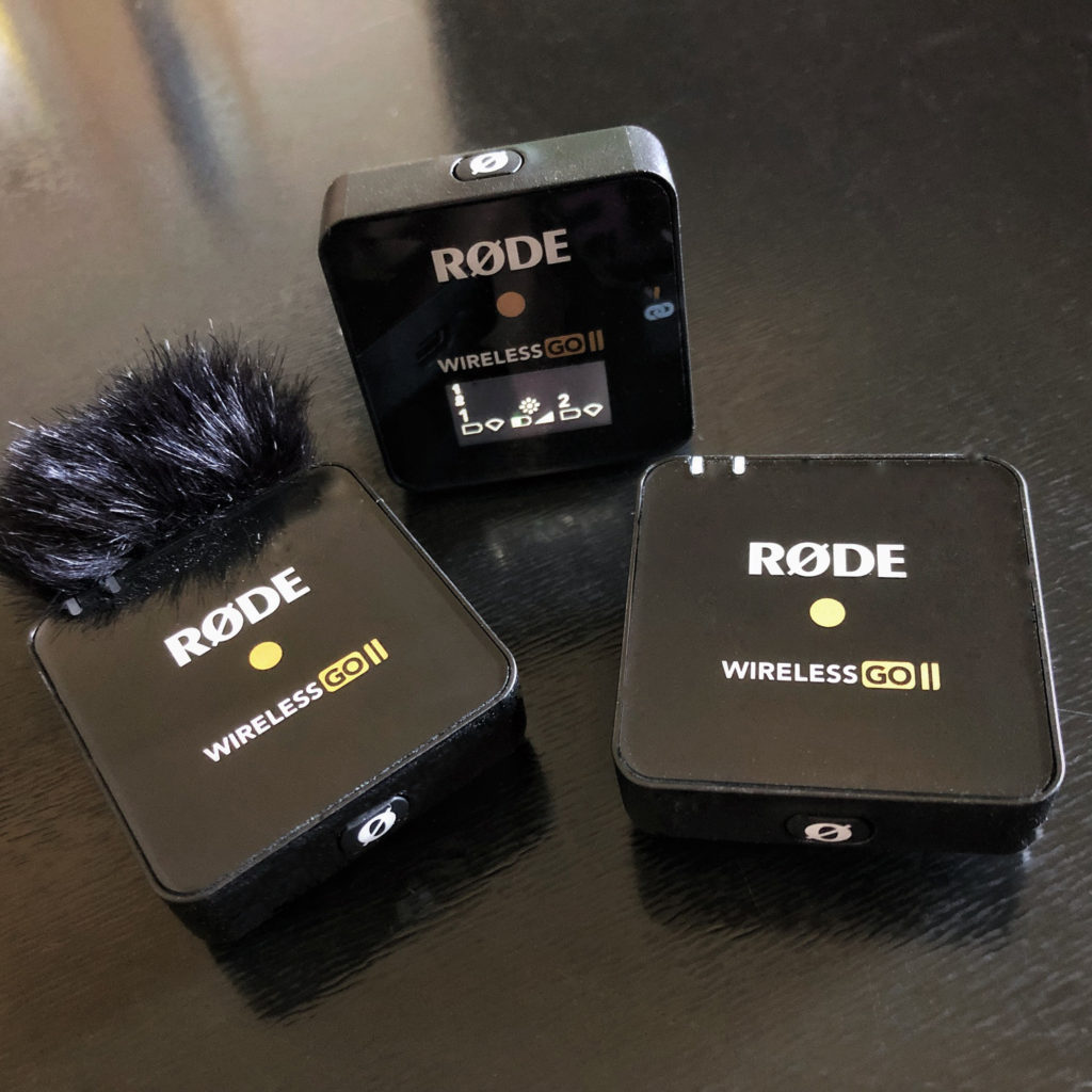 The Rode Wireless Go II system:

Receiver with LED screen set upright on a black tabletop. The two transmitters (one with a wind muff attached) are placed facing up on the table.