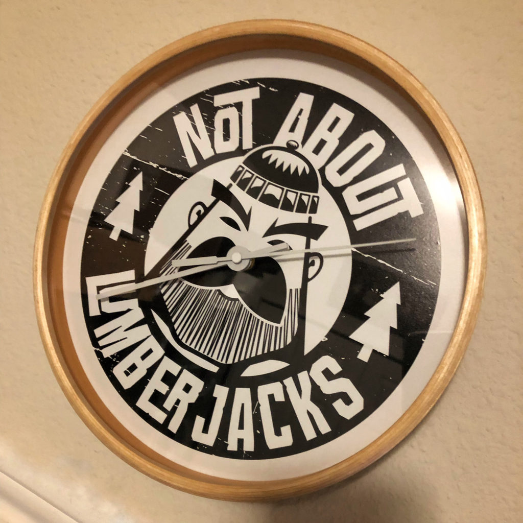 The Not About Lumberjacks lumberjack logo on the face of a clock that hangs in the office.
