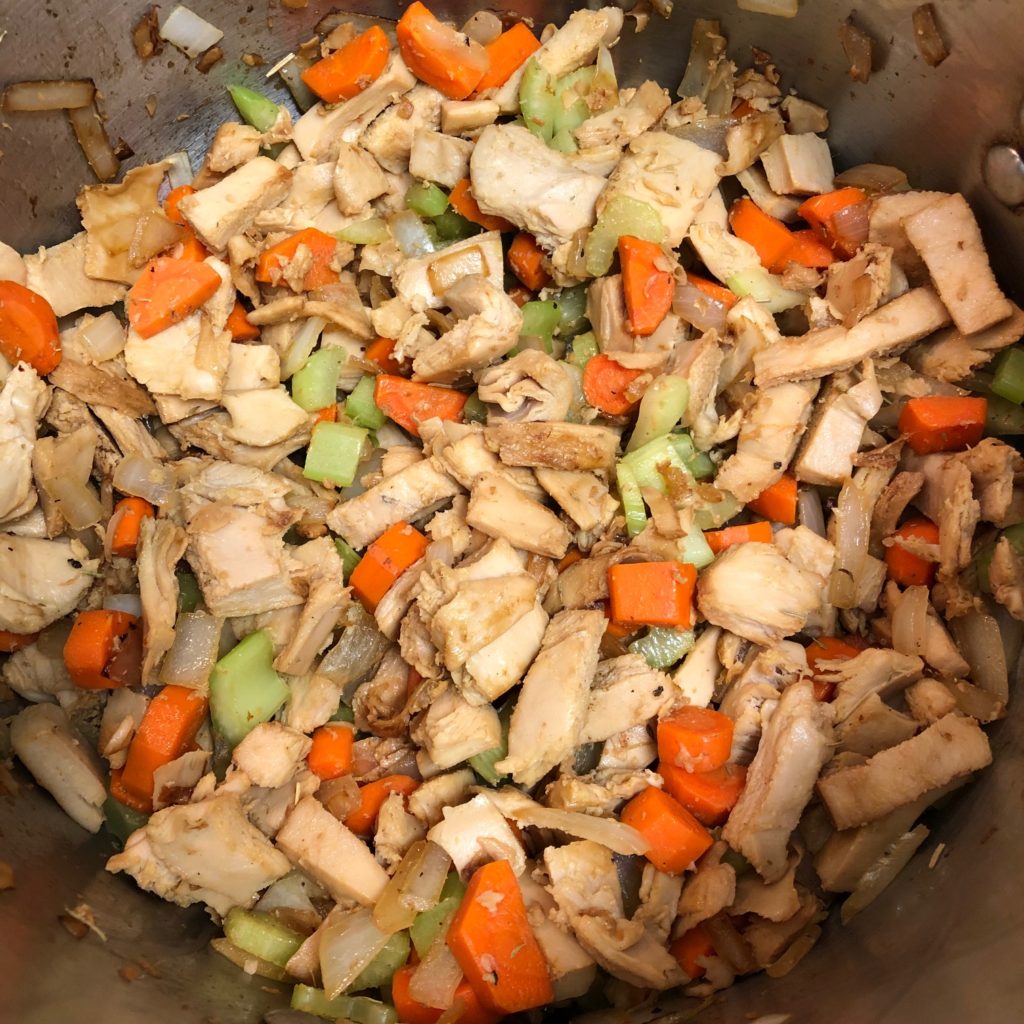 Onion, carrots, celery, and Sweet Earth faux chicken in a pot.