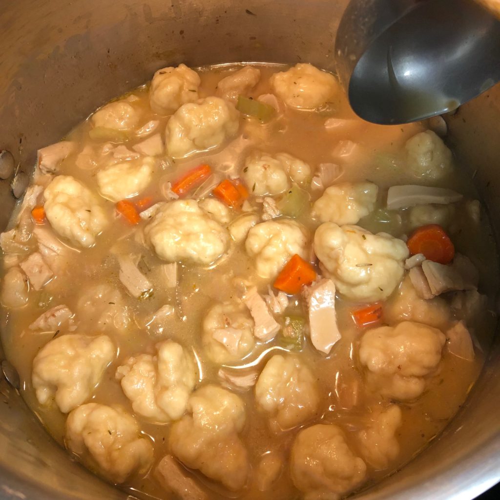 Vegan chicken and dumplings simmering in a pot.